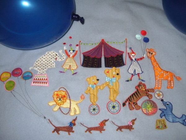 Hey Day Circus, machine embroidery designs, circus tent, flags, clown, juggling, balloons, elephant, giraffe, lion, hoop, daschund, dogs, seal, sleep my darling, teddy, unicycle, tiger wall hanging, blanket, children, fun